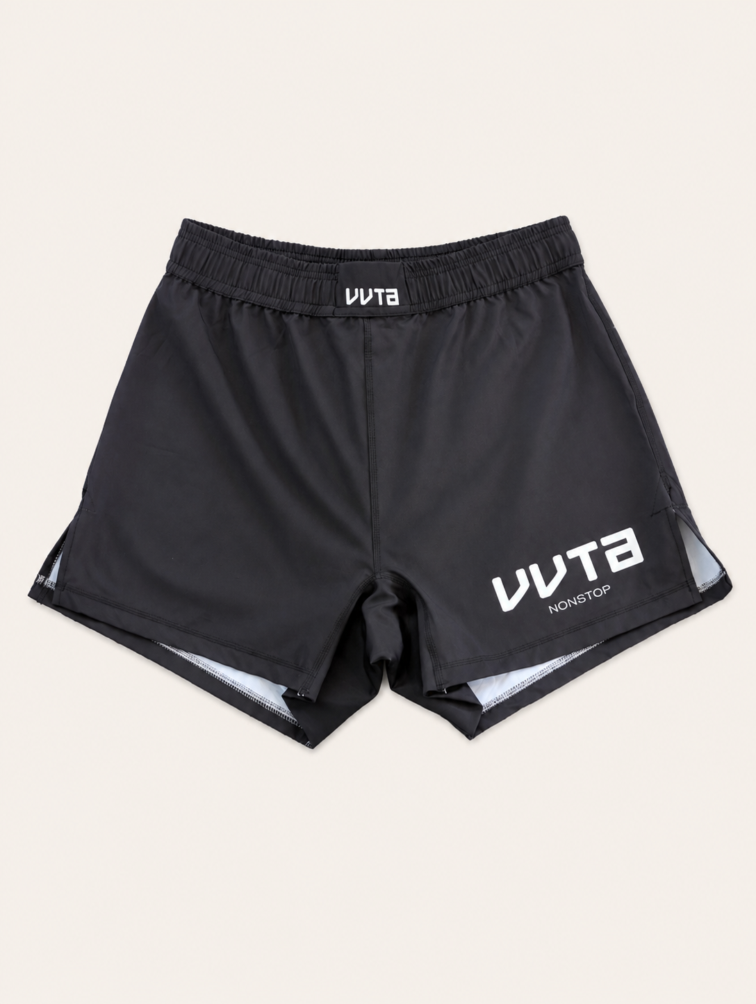 Black athletic shorts with white VVTA branding on the front, featuring an elastic waistband and a light gray inner lining visible at the hem, set against a solid off-white background.