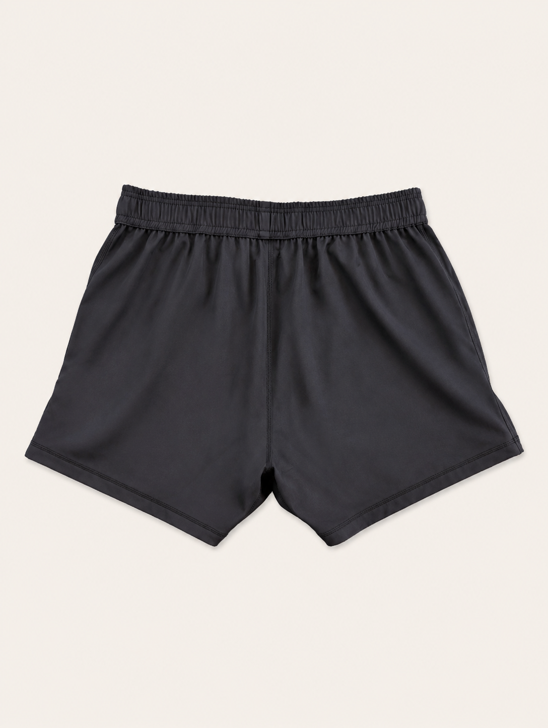 Black athletic shorts with an elastic waistband, shown flat against a light cream background.