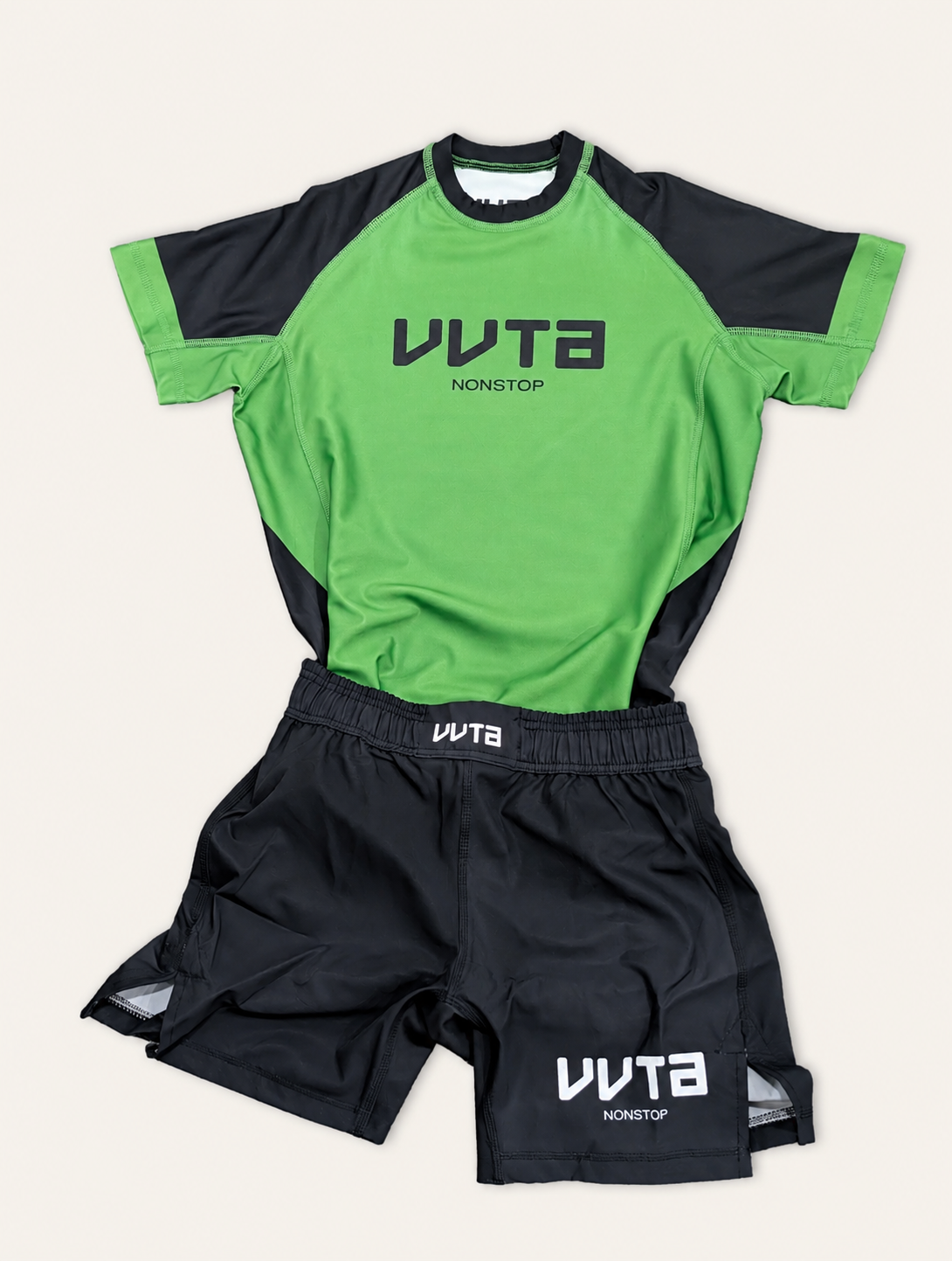 A two-piece athletic set featuring a bright green and black short-sleeve jersey and matching black shorts with white VUTA branding, laid flat on a light beige background.